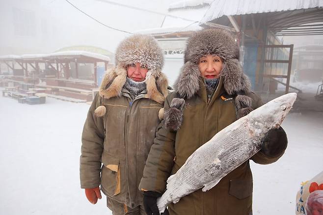 지난 15일(현지시간) 러시아 야쿠츠크에서 생선을 파는 상인들이 포즈를 취하고 있다. 사진 로이터연합뉴스