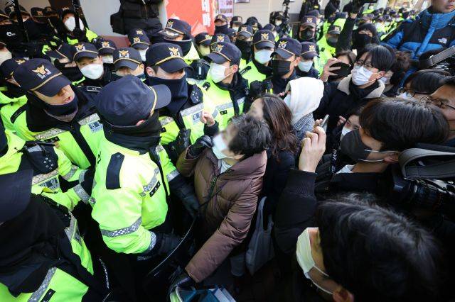 지난 18일 오전 국정원 압수수색이 이루어지고 있는 서울 중구 전국민주노동조합총연맹(민주노총) 서울 사무실 앞에서 민주노총 관계자들이 진입을 시도하며 경찰에 항의하고 있다. 연합뉴스