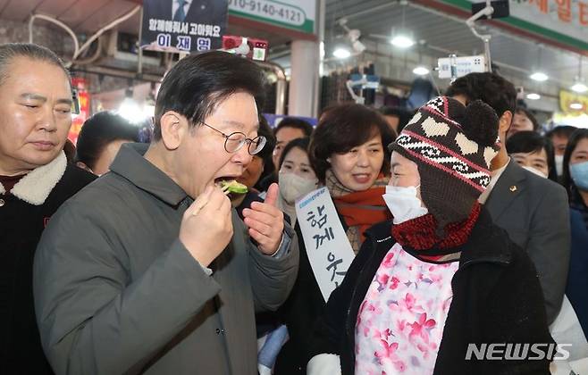 [인천=뉴시스] 추상철 기자=지난 19일 이재명 더불어민주당 대표가 인천 계양산전통시장에서 전을 시식하고 있다. 2023.01.19. scchoo@newsis.com