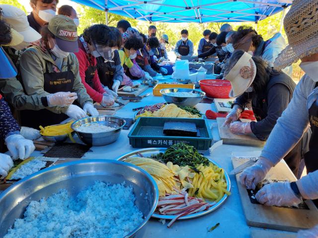 행복한동행 회원들이 대구 동구 효목동 망우당공원에서 효도급식 메뉴로 김밥을 준비하고 있다. 행복한동행 제공