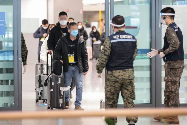 지난 9일 오전 인천국제공항 제1여객터미널에서 중국발 입국자들이 입국장으로 들어서며 방역 관계자의 안내를 받고 있다. 연합뉴스