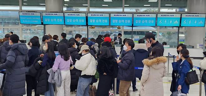 23일 오후 제주공항 내 대한항공 카운터에서 탑승권을 구하려는 승객들이 줄을 서 있다. 대한항공은 폭설이 예상됨에 따라 24일 제주공항 출발, 도착 항공편을 모두 결항하기로 했다./연합뉴스