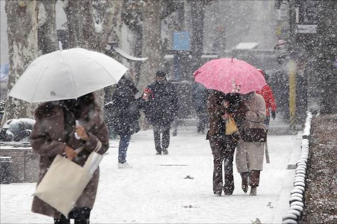 중부지방에 대설주의보가 내린 지난해 12월 15일 오후 서울 종로구 종묘 인근에서 시민들이 눈이 내리는 가운데 발걸음을 재촉하고 있다. ⓒ데일리안 홍금표 기자