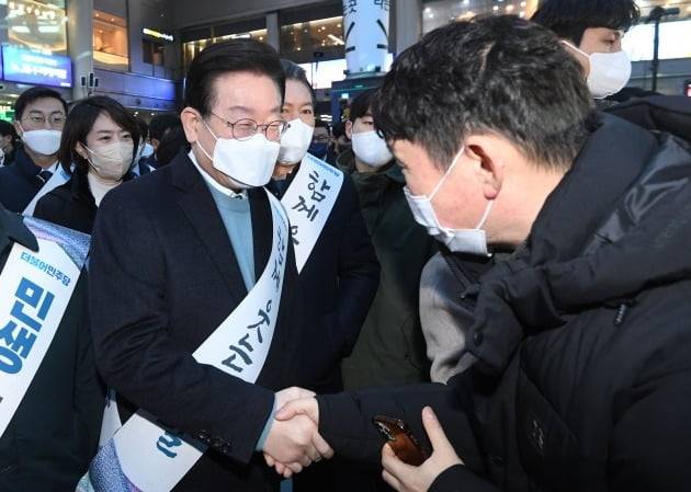 이재명 더불어민주당 대표가 설 연휴를 하루 앞둔 지난 20일 서울 용산역에서 귀성길에 오른 시민과 악수하고 있다. /연합뉴스