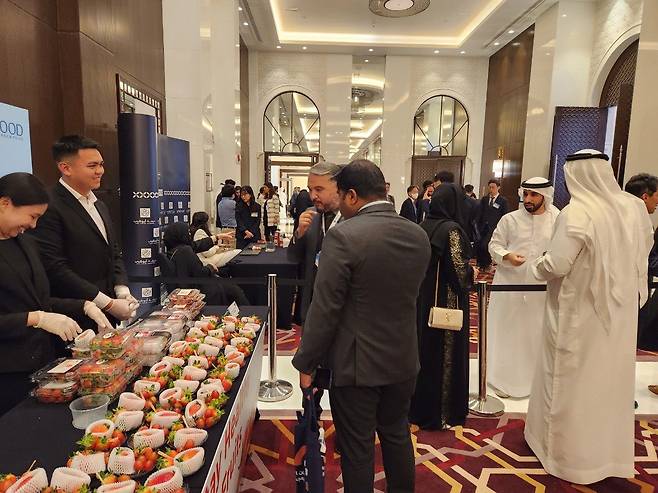 지난 16일(현지 시각) 아부다비 한 호텔에서 진행된 '한-UAE 비즈니스 포럼' 행사장 밖에서 한국 과일 시식 행사가 열렸다. 현지 바이어들이 딸기 등을 맛보고 있다. /농림축산식품부 제공