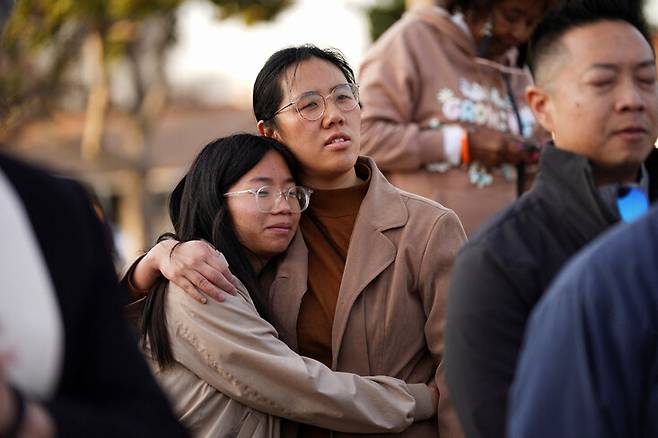 22일 미국 캘리포니아주 로스앤젤레스 인근 몬터레이파크에서 발생한 총기 난사 사건의 희생자들을 애도하며 아시아계 미국인 두명이 포옹하고 있다. 로이터 연합뉴스