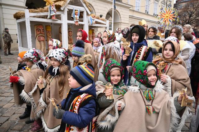 러시아의 우크라이나 침공이 한창인 6일 우크라이나 서부 도시 리비우에서 전통 의상을 입은 어린이들이 밝은 표정으로 정교회 크리스마스이브 축하 행사에 참여하고 있다. 리비우=AFP 연합뉴스