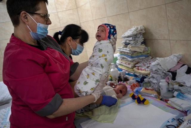 지난해 3월 19일 우크라이나 키이우의 한 보육원에서 보모가 신생아를 보고 있다. 키이우=AP 연합뉴스