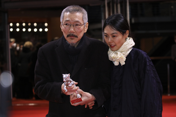 Hong Sang-soo, left, and actor Kim Min-hee pose with the Silver Bear Grand Jury Prize for the film ″The Novelist's Film″ (2022) after the awarding ceremony at the International Film Festival Berlin in Berlin, Germany on Feb. 16, 2022. [AP/YONHAP]