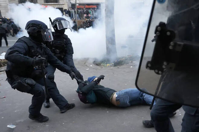 지난 19일(현지 시각) 프랑스 파리에서 연금 변경에 반대하는 시위 도중 진압 경찰이 시위자를 붙잡고 있다. /AFP=뉴스1
