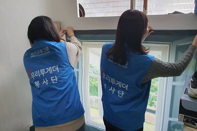 우리금융미래재단 직원들이 지난 18일 서울 용산구 쪽방촌을 찾아 주민들을 위해 방한커튼을 설치하고 있다. 우리은행 제공