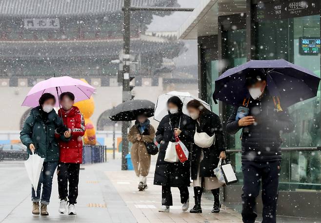 오는 26일은 최강 한파가 한풀 꺾이지만 수도권과 강원 등 중부지방을 중심으로 많은 눈이 내릴 전망이다.사진은 지난 15일 시민들이 눈이 내리는 서울 광화문광장을 우산을 쓰고 걸어가는 모습. /사진=뉴스1