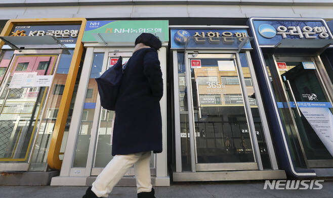 [서울=뉴시스] 김근수 기자 = 25일 서울 시내의 주요 시중은행 ATM 앞으로 한 시민이 지나가고 있다. 금융노사는 은행 영업시간 복구 막판 협의가 진행되면서 오는 30일 실내마스크 착용 의무 해제와 함께 시중은행 영업시간 정상화 가능성이 높다고 밝혔다. 2023.01.25. ks@newsis.com