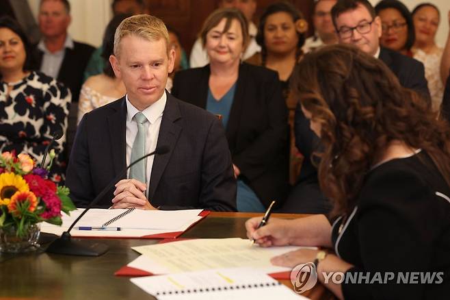 신임 총리 임명장에 서명하는 뉴질랜드 총독 (웰링턴 AFP=연합뉴스) 25일(현지시간) 크리스 힙킨스(왼쪽) 신임 뉴질랜드 총리가 웰링턴에 있는 뉴질랜드 총독 관저에서 신디 키로 총독(오른쪽)이 신임 총리 임명장에 서명하는 모습을 지켜보고 있다. 2023.1.25 photo@yna.co.kr