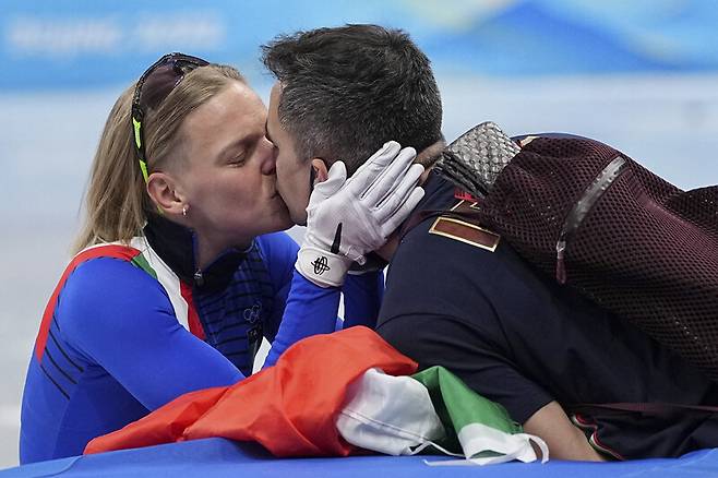이탈리아 아리안나 폰타나가 2022 베이징겨울올림픽 쇼트트랙 여자 500m에서 1위로 결승선을 통과한 뒤 남편 앤서니 로벨로 코치와 키스하고 있다. 베이징/AP 연합뉴스
