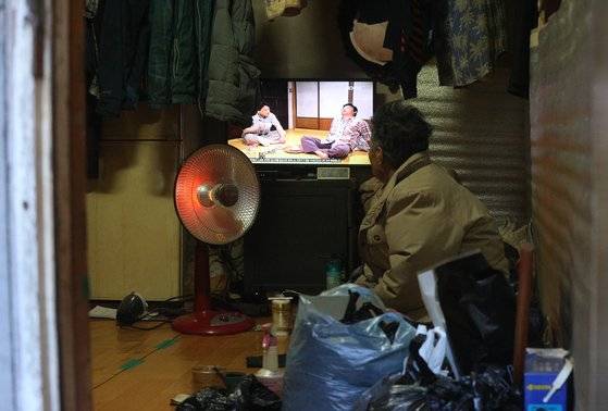 25일 서울 용산구 쪽방촌 거주 노인이 온열기기 하나에 의지해 추위를 견디고 있다. [뉴스1]