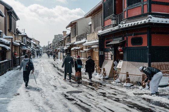 25일 일본 교토에서 시민들이 눈 쌓인 거리를 지나고 있다. AFP=연합뉴스