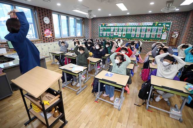 지난 25일 대구시 수성구 대구동천초등학교에서 설 연휴까지 이어진 겨울방학을 끝내고 개학을 맞은 2학년 학생들이 선생님과 인사를 나누고 있다.[연합]