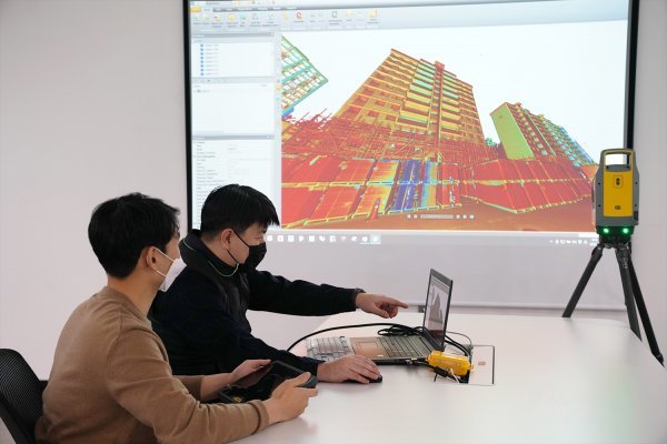 롯데건설 관계자가 3D 스캐너를 활용한 아파트 모델링 데이터를 확인하고 있다. 사진제공 ｜ 롯데건설