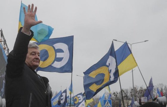 반역 혐의를 받는 페트로 포로셴코 전 우크라이나 대통령이 17일(현지시간) 키예프 공항에 도착해 지지자들에게 손을 흔들어 보이고 있다. [EPA=연합뉴스]