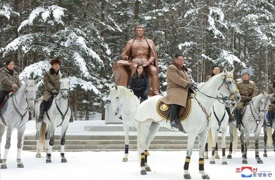 김정은 북한 국무위원장이 군 간부들과 함께 군마를 타고 백두산을 등정했다고 조선중앙통신이 지난 2019년 12월 4일 보도했다. 김 위원장이 백마 위에 올라타 있다. 검은 옷을 입은 여성은 부인 이설주 여사.연합뉴스