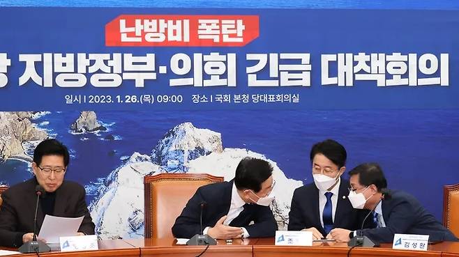 Lee Jae-myung (second from left), leader of the Democratic Party of Korea, speaks with the party’s secretary general Cho Jeong-sik and Kim Sung-whan, chair of the party’s policy committee, in an emergency meeting of the party’s local government representatives and council members to discuss the soaring heating bill at the National Assembly on January 26. Yonhap News