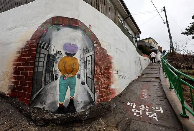 논골담길 ‘바람의 언덕’으로 탐방객들이 올라가고 있다. 이곳에선 벽화를 담에 그렸다 해서 ‘담화’라 부른다.