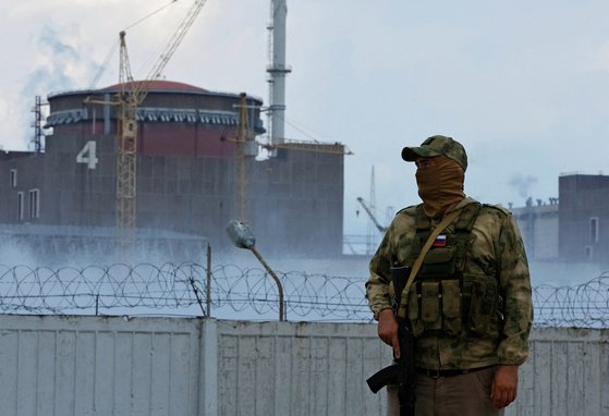지난 4일 러시아군인이 우크라이나 자포리자 원전 앞에서 경비를 서고 있다. 자포리자 원전은 3월 초 러시아군이 점령했다. 로이터=연합뉴스