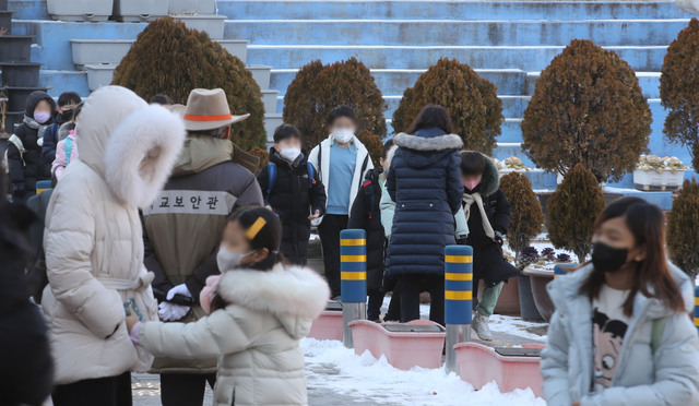 서울 한 초등학교에서 27일 오후 학생들이 마스크를 쓴 채 하교하고 있다. 교육부 지침에 따라 오는 30일부터는 실외는 물론 교실에서도 마스크 착용이 의무에서 권고로 완화된다.뉴시스