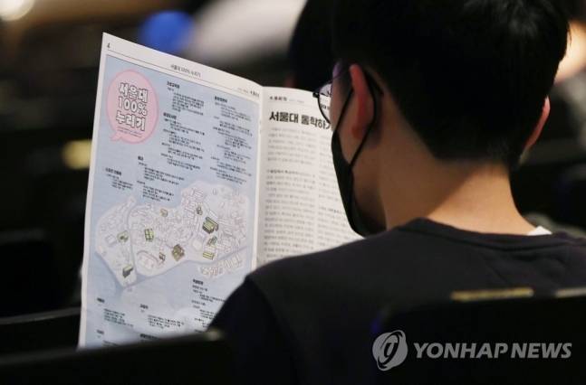 관악구 서울대학교에서 열린 2023학년도 신입생 오리엔테이션에 참가한 예비 대학생이 학교 안내 책자를 읽고 있다. <자료=연합뉴스>