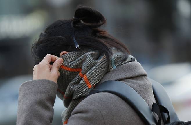 다시 겨울 한파가 찾아온 지난 27일 오전 두꺼운 옷차림을 한 출근길 시민이 광화문네거리를 지나고 있다.   연합뉴스