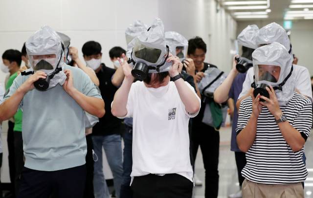 지난해 8월 24일 오후 인천시 부평구 부평구청역에서 진행된 화생방 테러 대응 합동 훈련에서 민방위 대원들이 방독면 착용을 연습하고 있다. 연합뉴스