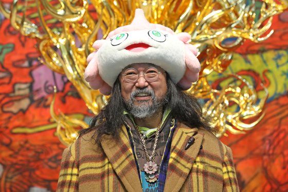 부산시립미술관에서 26일 개막한 자신의 전시를 위해 한국을 찾은 일본 아티스트 무라카미 다카시. 자신이 직접 만든 캐릭터 인형 모자를 쓰고 전시장에 나타났다. [사진 뉴시스]