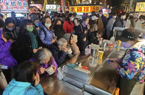 춘절을 맞은 타이페이 시민이 지난 25일(현지시간) 전통시장에서 음식을 먹고 있다. AP 연합뉴스
