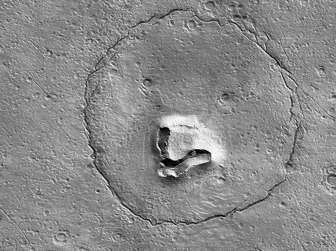최근 미국 애리조나대 연구진이 공개한 화성 표면 사진에 곰의 얼굴을 연상하게 하는 모습이 찍혔다. 눈은 충돌구가 만들어지면서, 코는 표면 지형이 무너지며 생긴 것으로 보인다. 애리조나대·NASA 제공