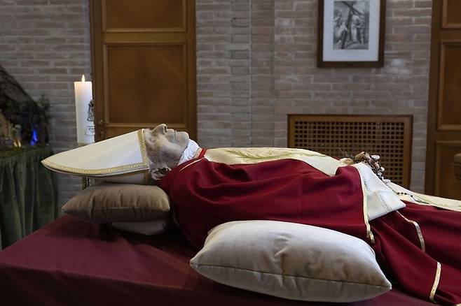 베네딕토 전 교황의 시신은 그가 여생을 보낸 바티칸시국의 ‘교회의 어머니(Mater Ecclesiae)’ 수도원에 안치돼 있다. 16세가 머리에 모관을 쓰고 전통적인 교황 제의를 입고 관대 위에 누워 있는 모습을 담았다.  [사진 = 연합뉴스]