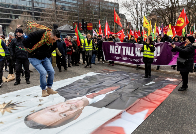 21일(현지 시간) 스웨덴 스톡홀롬에서 열린 반튀르키예 시위에서 시위대가 에르도안 대통령 현수막을 짓밟고 있다.로이터연합뉴스