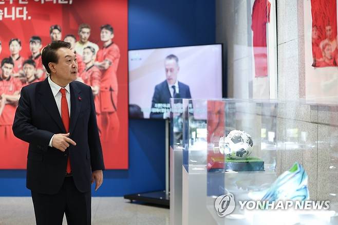 용산 대통령실 청사에 카타르 월드컵 축구 국가대표팀 기념품 전시 (서울=연합뉴스) 안정원 기자 = 윤석열 대통령이 지난 12일 서울 용산 대통령실 청사 로비에서 카타르 월드컵 16강에 진출한 축구 국가대표팀 주장 손흥민 선수의 주장 완장과 사인볼, 축구화, 유니폼 등 전시된 기념품을 살펴보고 있다. 2022.12.13 [대통령실 제공. 재판매 및 DB 금지] jeong@yna.co.kr