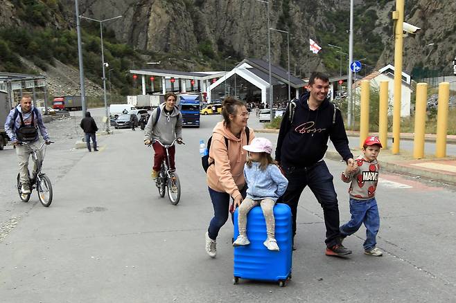 지난 28일 러시아 인접 조지아 국경지역에서 한 러시아 가족이 걸어서 이동하고 있다. AP=연합뉴스