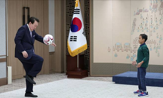 윤석열 대통령(왼쪽)이 31일 서울 용산 대통령실 청사에서 캄보디아 소년 로타를 만나 축구를 하고 있다. 대통령실 제공