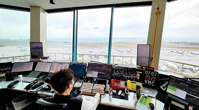 날아오르는 항공기와 제주공항 관제탑     (제주=연합뉴스) 변지철 기자 = 지난 1월 27일 촬영한 제주공항 관제탑 내부 모습. 창문 너머로 항공기가 이륙하는 모습이 보인다. 2023.2.1