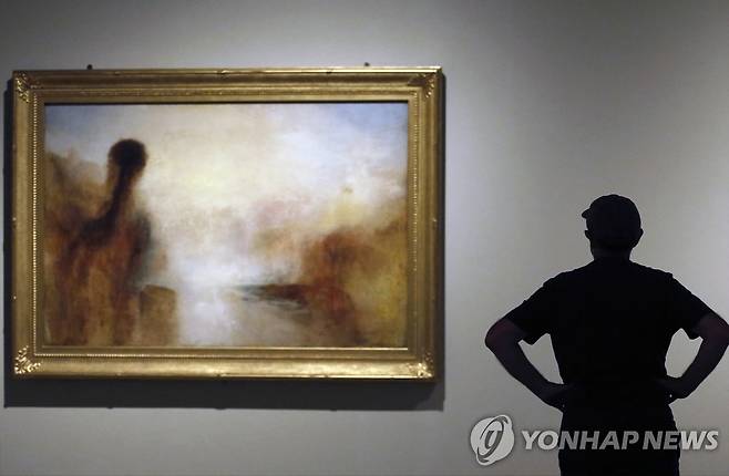 윌리엄 터너의 작품 앞 관람객 한 관람객이 2022년 5월 19일(현지시간) 스페인 바르셀로나의 미술관에 전시된 영국 화가 윌리엄 터너의 작품을 보고 있다. [EPA 연합뉴스 자료사진. 재판매 및 DB 금지]