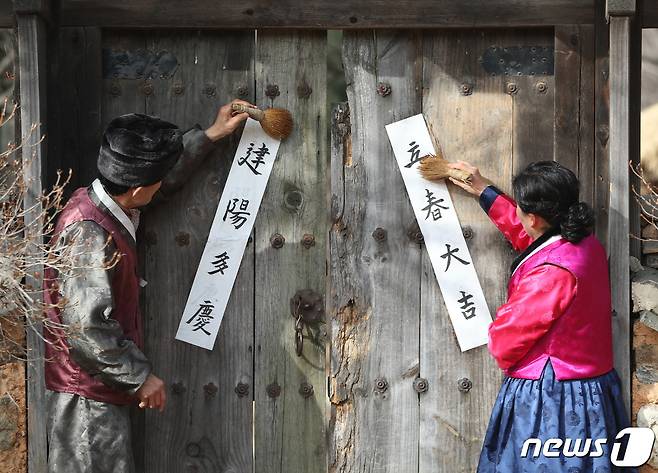 절기상 입춘(立春)을 이틀 앞둔 2일 오전 경기 용인시 기흥구 한국민속촌에서 직원들이 입춘대길(立春大吉)과 건양다경(建陽多慶)이라고 적은 입춘첩을 붙이고 있다. 2023.2.2/뉴스1 ⓒ News1 김영운 기자