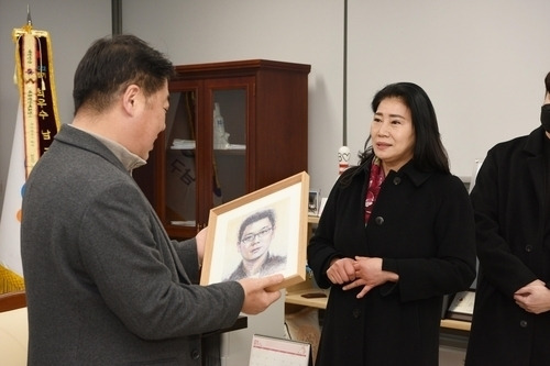 오은택 부산 남구청장이 하계순씨에게 아들 초상화를 전달하고 있다. 부산 남구 제공