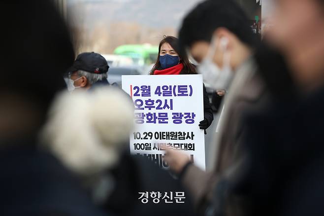 이태원 참사 유가족이 2일 서울 종로구 세종대로 사거리에서 이태원 참사 100일 추모대회 참여를 호소하는 팻말을 들고 있다. |권도현 기자