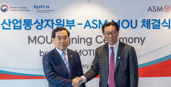 Industry Minister Lee Chang-yang, left, and ASM CEO Benjamin Loh shake hands at a ceremony marking the signing of an MOU on Thursday in central Seoul. [YONHAP]