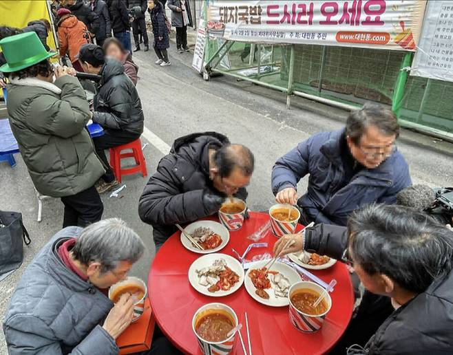 2일 오후 대구 북구 이슬람사원 공사현장 앞에서 대현동 주민들이 돼지수육과 소고기국밥을 먹고 있다. 대구=뉴시스