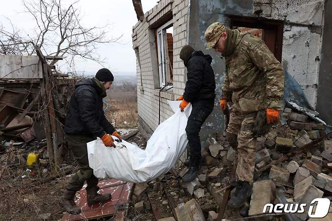 18일(현지시간) 우크라이나 동부 도네츠크주 돌리나에서 우크라이나 자원봉사자들이 마을에 묻힌 러시아군 시신을 발굴해 운반하고 있다. 2023.1.18. ⓒ AFP=뉴스1 ⓒ News1 김성식 기자