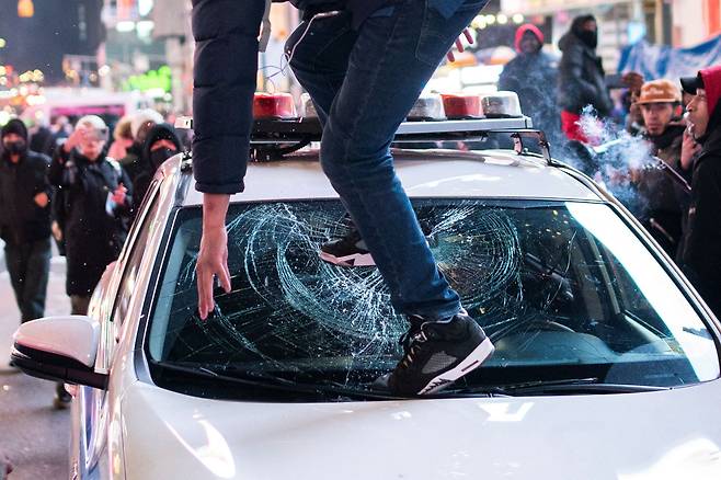 미국 테네시주 멤피스에서 경찰관들의 폭행에 숨진 흑인 청년 타이어 니컬스를 때리는 영상이 공개된 1월 27일 미국 뉴욕에서 벌어진 규탄 시위에서 한 남성이 경찰 차량위에 올라가 발로 차 유리를  부수고 있다. /로이터 연합뉴스