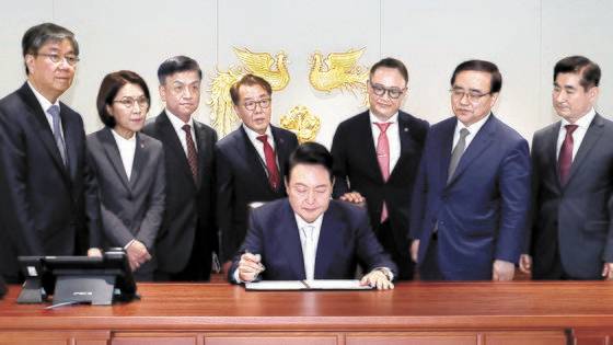 윤석열 대통령이 지난해 5월 서울 용산에 새로 마련된 대통령 집무실에서 1호 법안에 서명하고 있다. 당시 뒷줄에 서 있던 최영범 홍보수석과 강인선 대변인은 물러난 상태다. [연합뉴스]